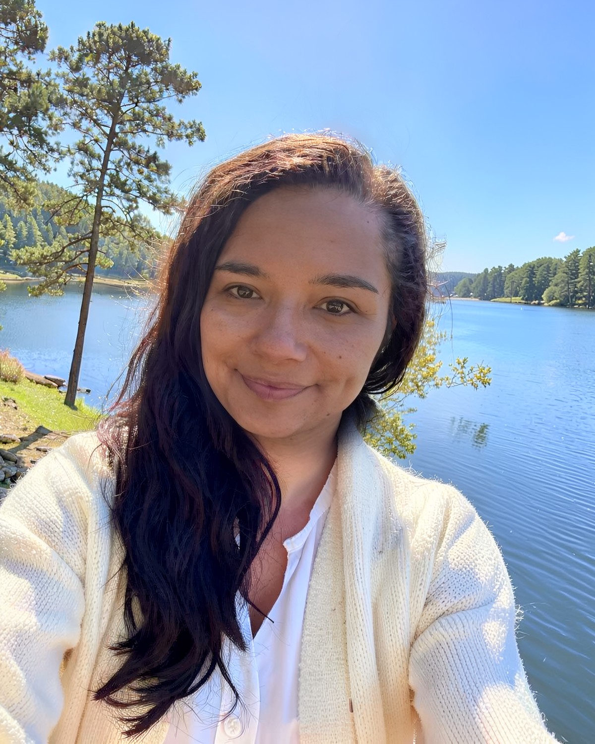 Ashley Romero, founder of Hometown Serenity, smiling outdoors by a lake